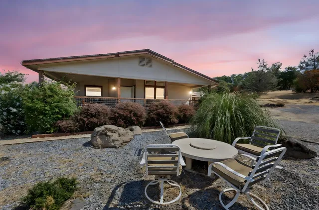 a backyard of a house with table and chairs