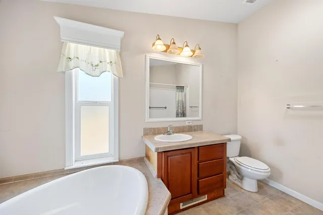 a bathroom with a sink vanity mirror and toilet
