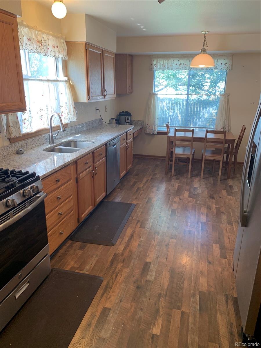 1187 West 133rd Way Westminster, CO 80234 - Photo 3 of 10 a kitchen with stainless steel appliances granite countertop a stove a sink and a microwave