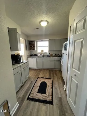 a kitchen with a refrigerator sink and wooden floor