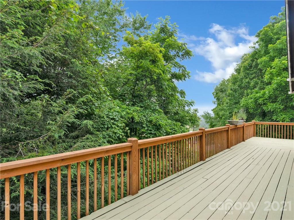 920 Hall Top Road Waynesville, NC 28786 - Photo 12 of 36 a balcony with wooden floor and trees in the background