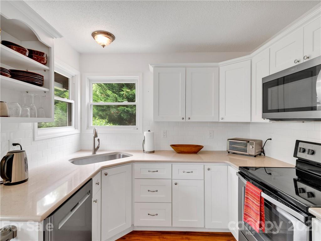 920 Hall Top Road Waynesville, NC 28786 - Photo 15 of 36 a kitchen with stainless steel appliances granite countertop a sink a stove and a microwave