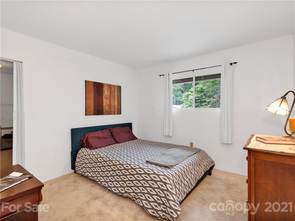 920 Hall Top Road Waynesville, NC 28786 - Photo 17 of 36 a bedroom with a large bed and a window