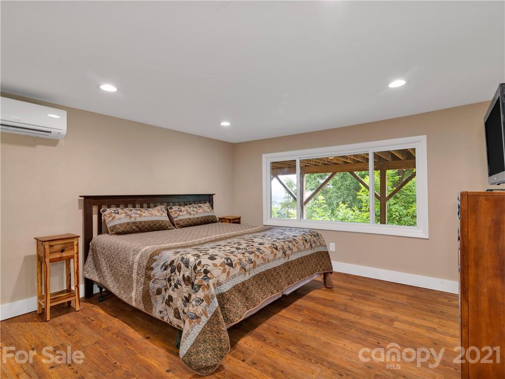 920 Hall Top Road Waynesville, NC 28786 - Photo 26 of 36 a bedroom with a large bed and a large window
