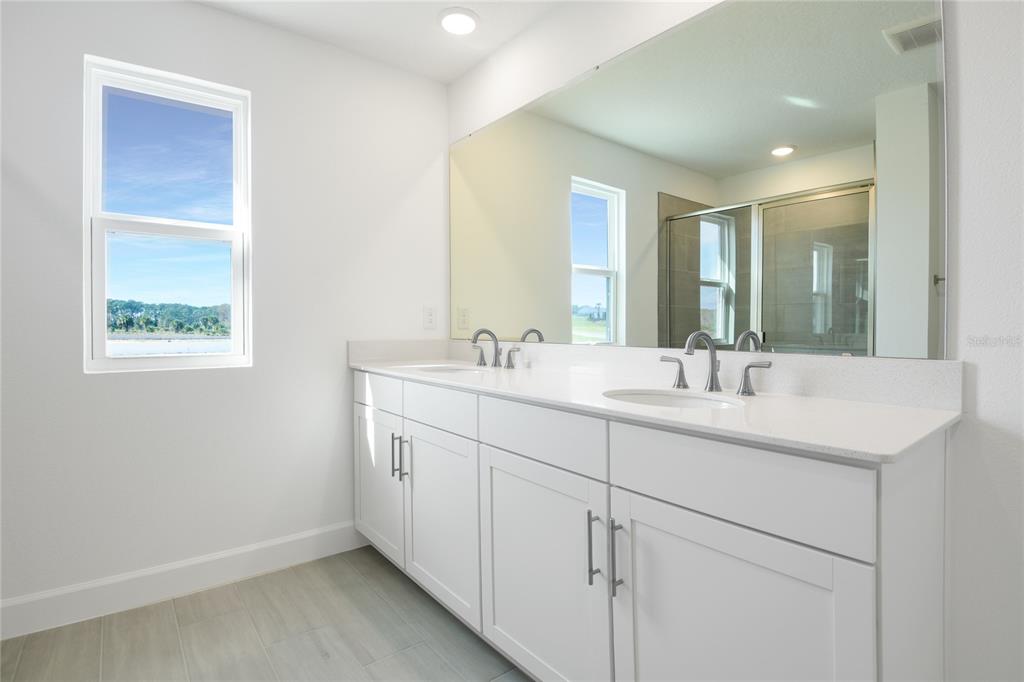 153 Waterstone Loop Tavares, FL 32778 - Photo 12 of 22 a bathroom with 2 sink and a mirror