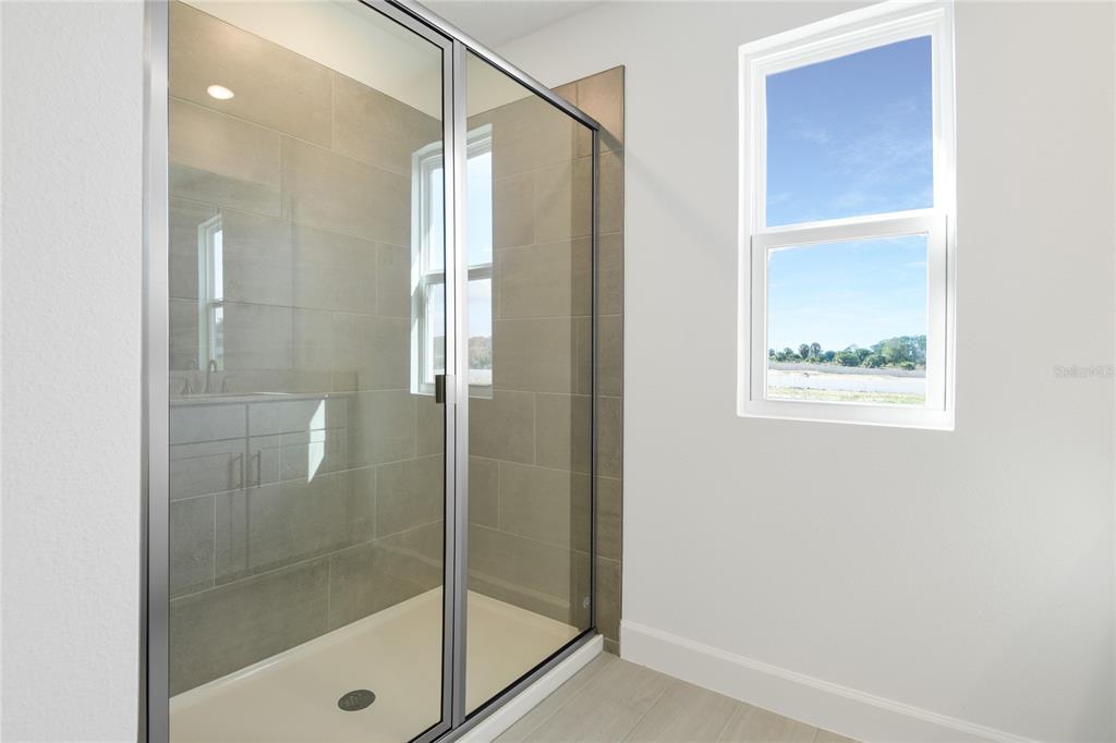 153 Waterstone Loop Tavares, FL 32778 - Photo 13 of 22 a bathroom with a glass shower door