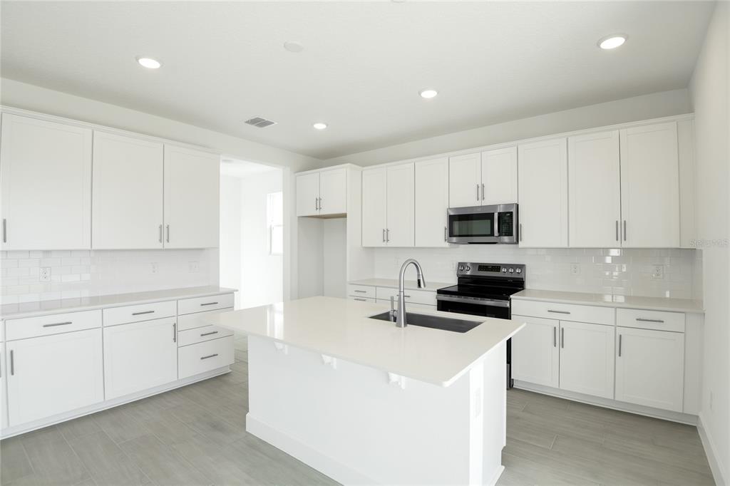 153 Waterstone Loop Tavares, FL 32778 - Photo 6 of 22 a kitchen with cabinets a sink and white appliances