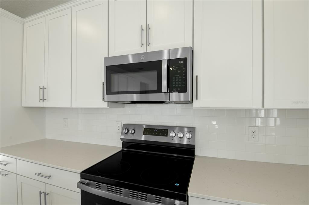 153 Waterstone Loop Tavares, FL 32778 - Photo 8 of 22 a kitchen with a stove and a microwave