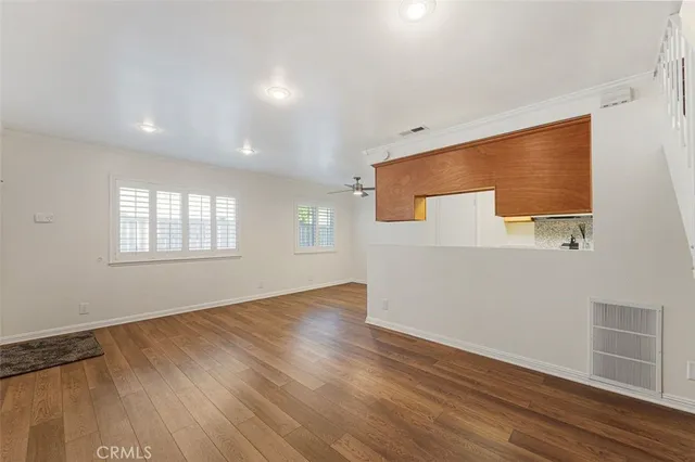 a kitchen with stainless steel appliances granite countertop a sink a stove and a refrigerator with wooden floor