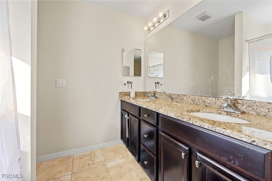 8657 Sumner Avenue Fort Myers, FL 33908 - Photo 17 of 29 a bathroom with a granite countertop sink and a mirror