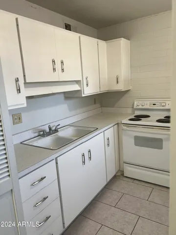a kitchen with white cabinets and white appliances