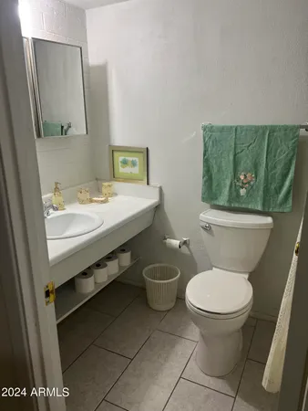 a bathroom with a granite countertop toilet a sink and a mirror