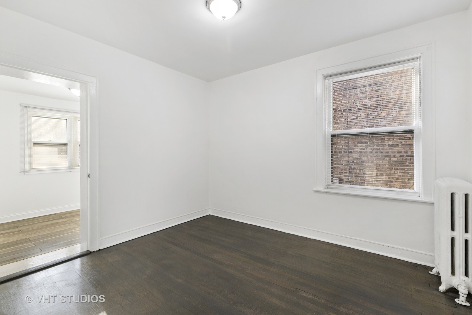 8030 South Justine Street Chicago, IL 60620 - Photo 7 of 12 an empty room with wooden floor and windows
