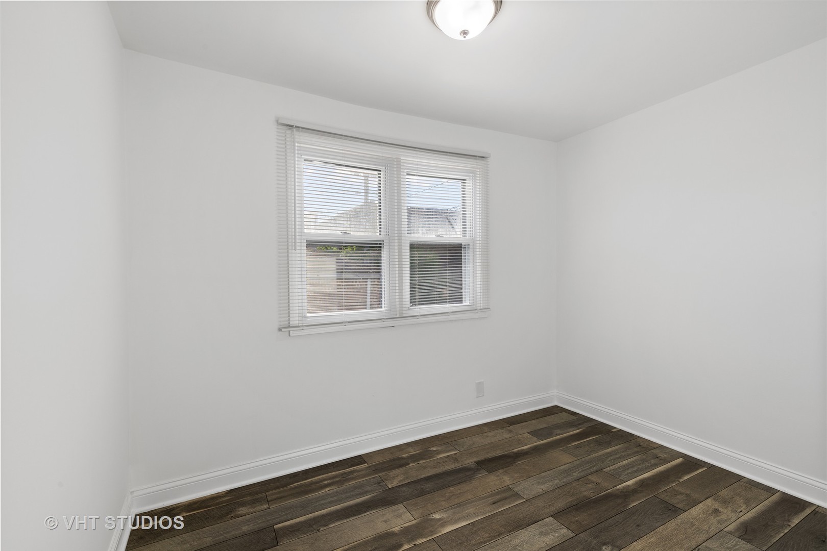 8030 South Justine Street Chicago, IL 60620 - Photo 8 of 12 an empty room with wooden floor and windows