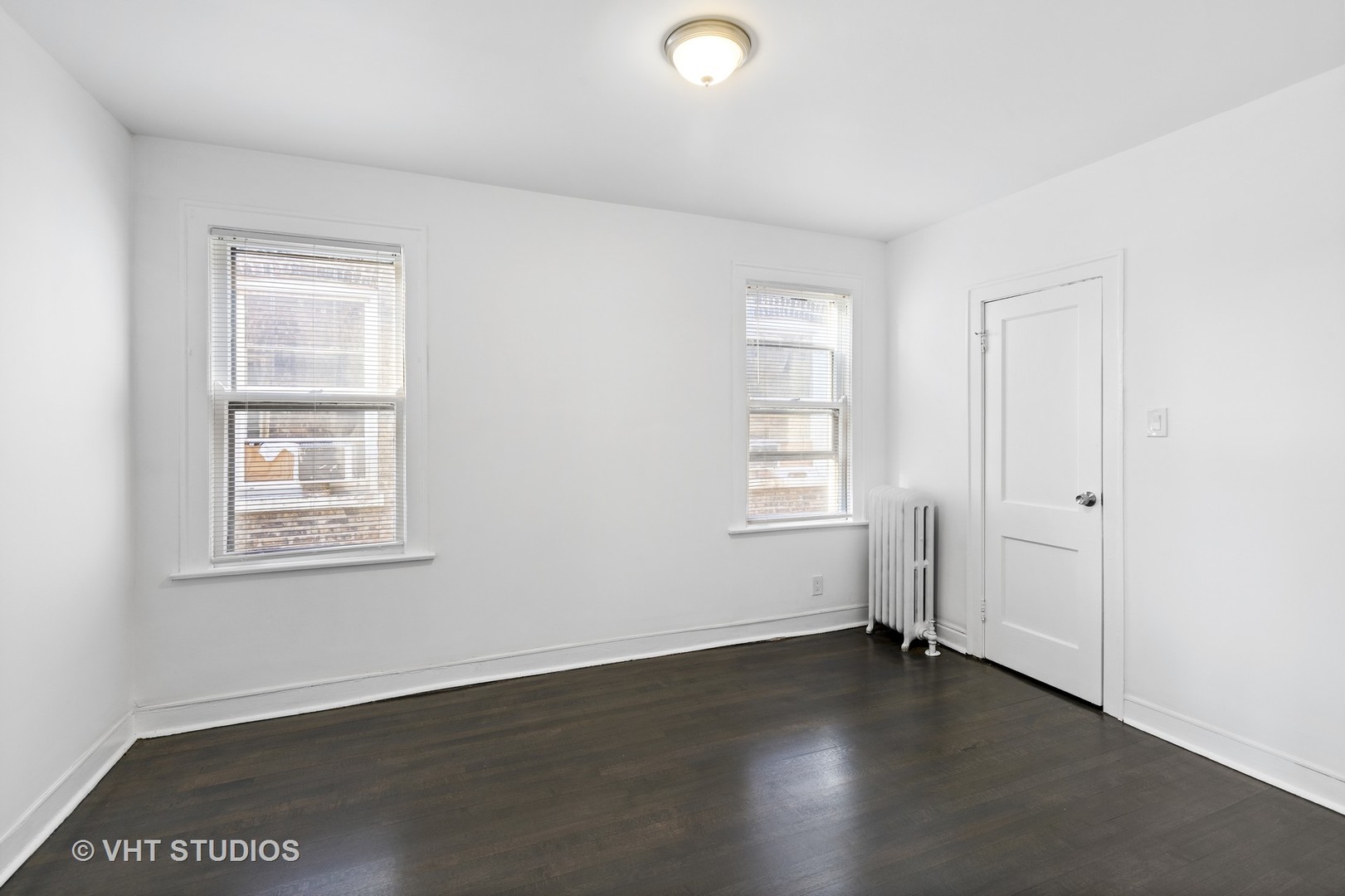 8030 South Justine Street Chicago, IL 60620 - Photo 10 of 12 an empty room with wooden floor and windows