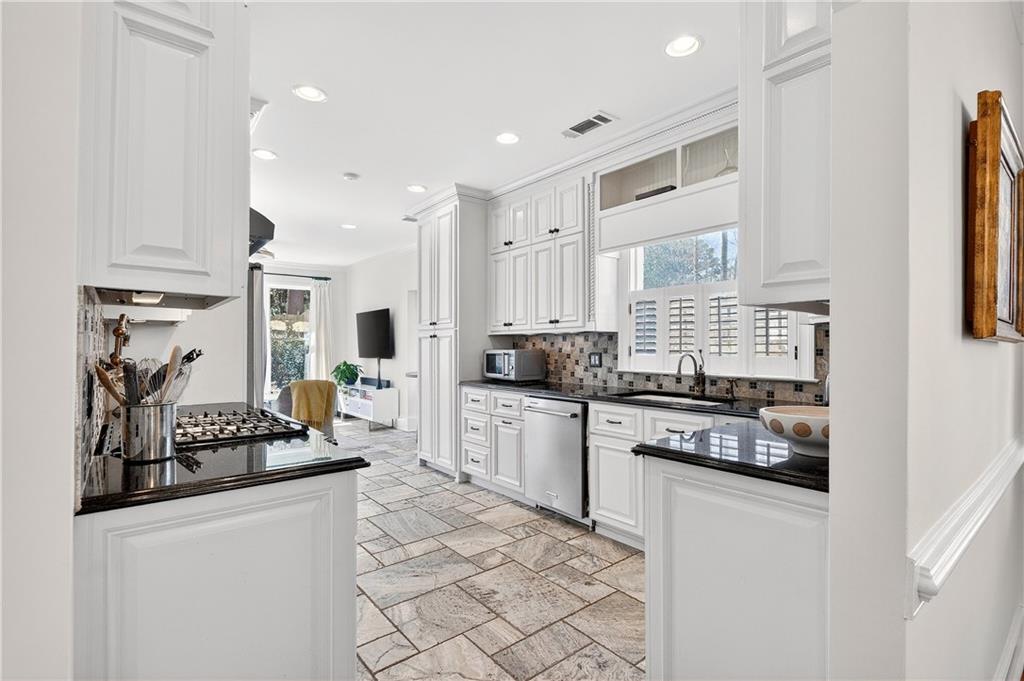 1197 Beech Valley Road Northeast Atlanta, GA 30306 - Photo 10 of 31 a kitchen with stainless steel appliances kitchen island granite countertop a stove and white cabinets