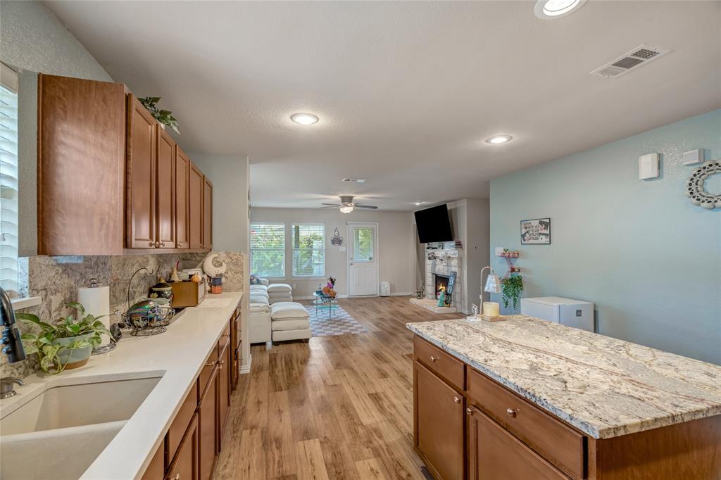 3216 Jetranger Road Fort Worth, TX 76053 - Photo 35 of 35 Kitchen featuring brown cabinets, open floor plan, backsplash, light wood-style floors, and recessed lighting