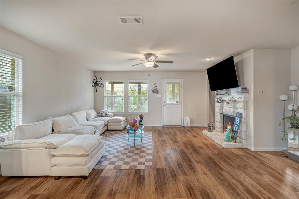 3216 Jetranger Road Fort Worth, TX 76053 - Photo 15 of 35 Living area with wood finished floors, ceiling fan, and a stone fireplace