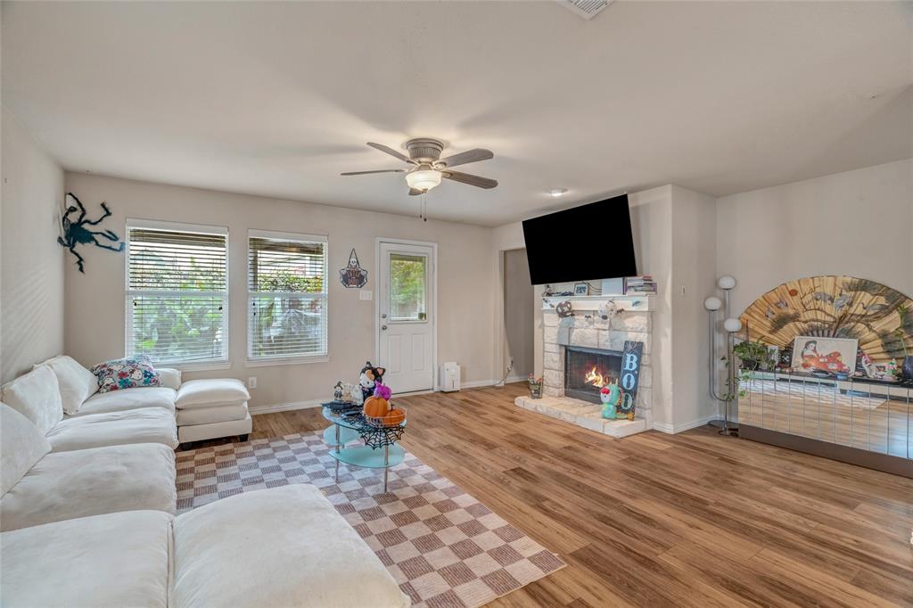 3216 Jetranger Road Fort Worth, TX 76053 - Photo 16 of 35 Living room featuring wood finished floors, ceiling fan, and a fireplace
