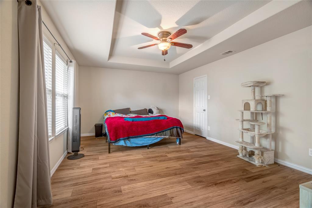 3216 Jetranger Road Fort Worth, TX 76053 - Photo 25 of 35 Bedroom with a raised ceiling, light wood-style floors, and a ceiling fan