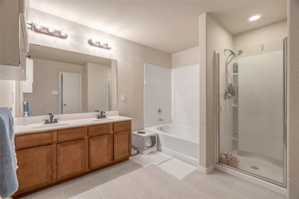 3216 Jetranger Road Fort Worth, TX 76053 - Photo 26 of 35 Full bath with a stall shower, double vanity, a garden tub, light tile patterned flooring, and a textured wall
