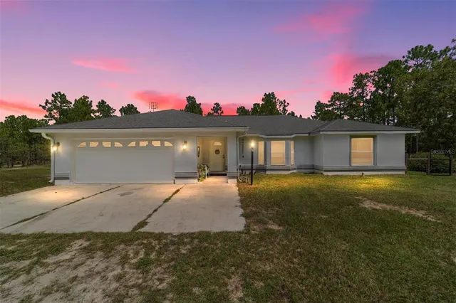 a view of a house with a yard and a garage