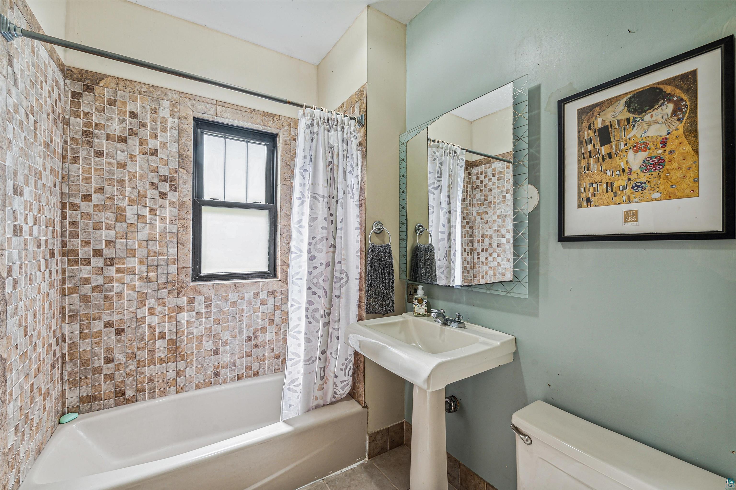 4516 Gladstone Street Duluth, MN 55804 - Photo 11 of 20 Bathroom with tile flooring, shower / tub combo with curtain, and toilet