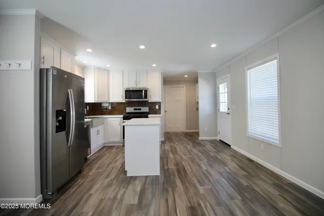 a kitchen with stainless steel appliances granite countertop a refrigerator stove microwave and sink