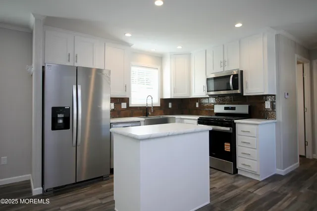 a kitchen with stainless steel appliances granite countertop a refrigerator a sink a stove a microwave and island