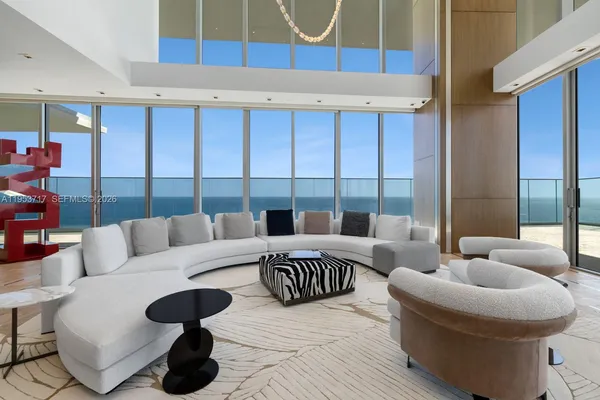 a kitchen with stainless steel appliances granite countertop a living room a stove and a refrigerator