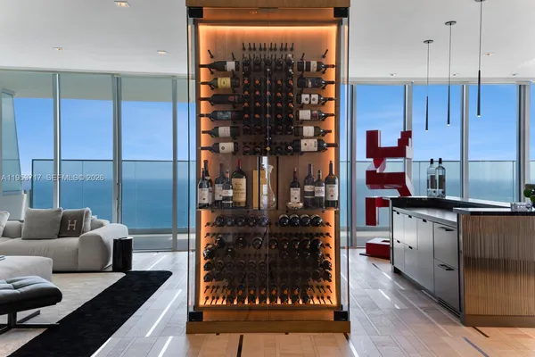 a large kitchen with kitchen island a stove a sink a refrigerator and a dining table with wooden floor