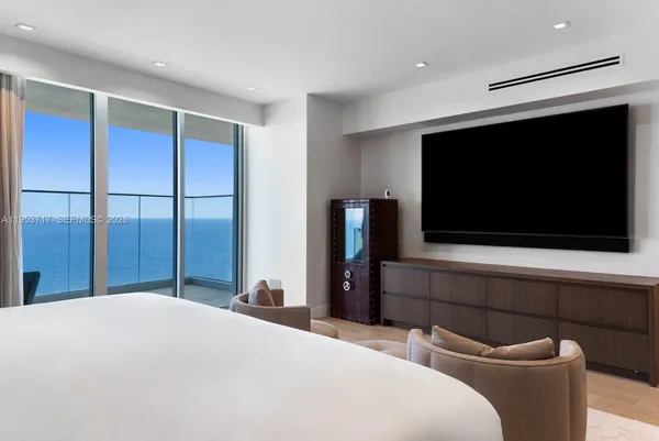 a bedroom with a large bed and a chandelier