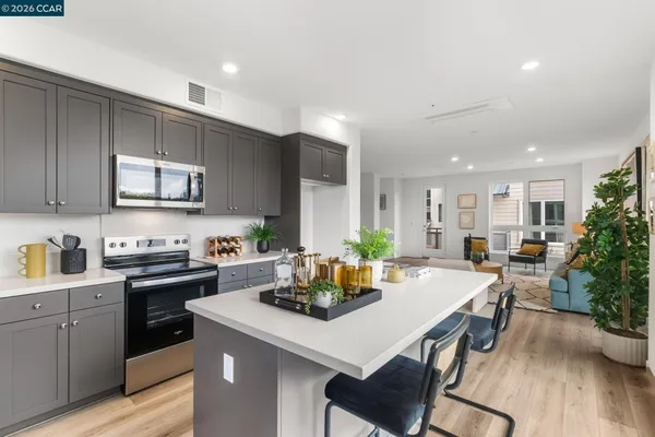 a kitchen with a stove a sink dishwasher a dining table and chairs with wooden floor