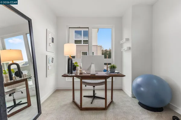 a view of a workspace room with wooden floor and furniture