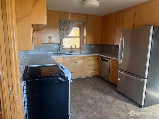 a kitchen with a refrigerator sink and cabinets