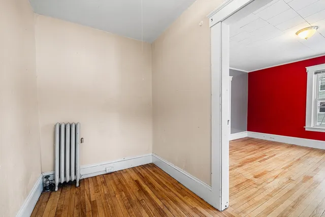 a view of empty room with wooden floor