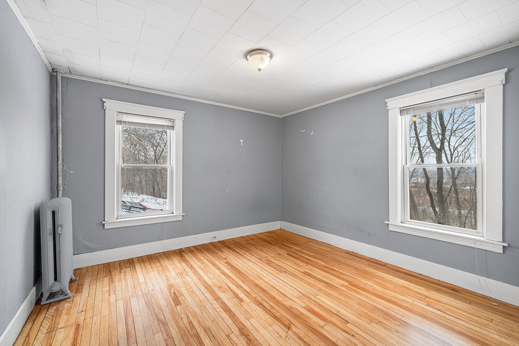 748 Water Street Fitchburg, MA 01420 - Photo 24 of 39 a view of an empty room with wooden floor and a window