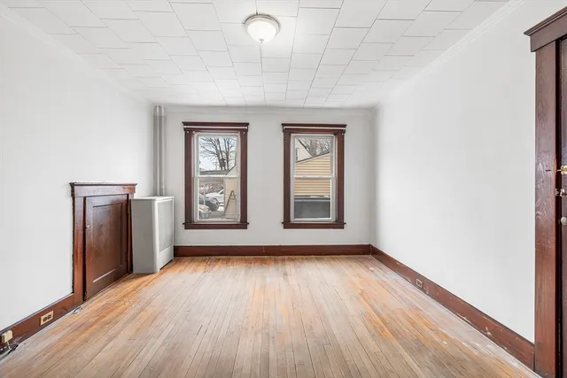 a view of an empty room with glass door and wooden floor