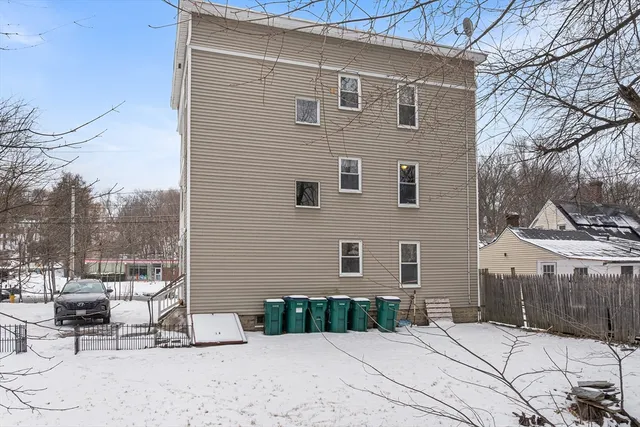 a backyard of a house with a bench and chairs