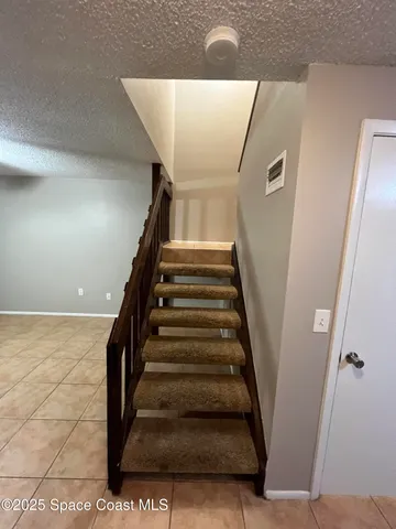 a view of an empty room with closet and a window