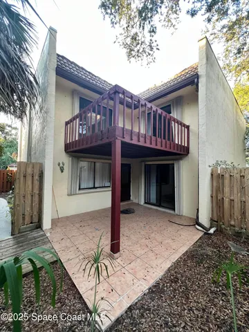 a view of a house with large windows and a small yard