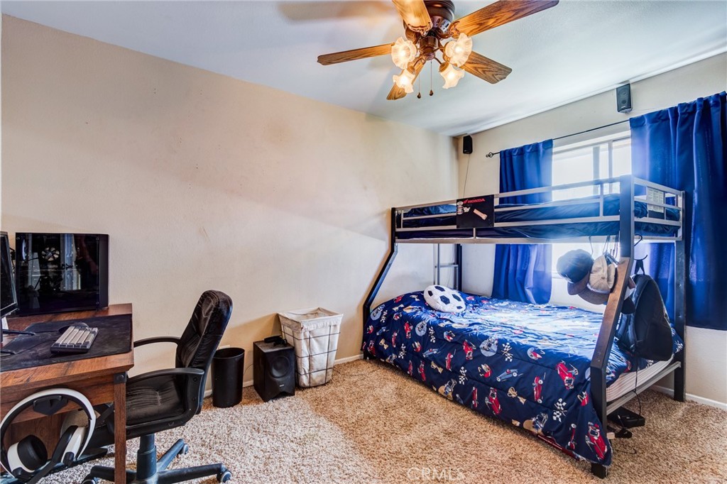 10163 Ponderosa Road Pinon Hills, CA 92372 - Photo 11 of 35 a bedroom with a bed and a chandelier