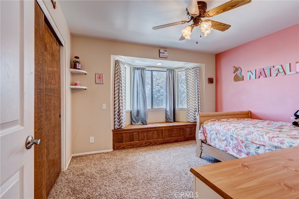 10163 Ponderosa Road Pinon Hills, CA 92372 - Photo 13 of 35 a bedroom with a bed and a chandelier