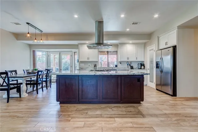 a view of kitchen with cabinets stainless steel appliances dining table and chairs