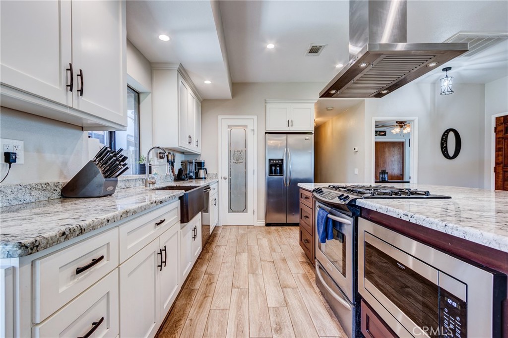 10163 Ponderosa Road Pinon Hills, CA 92372 - Photo 8 of 35 a kitchen with stainless steel appliances granite countertop a stove a sink and a refrigerator
