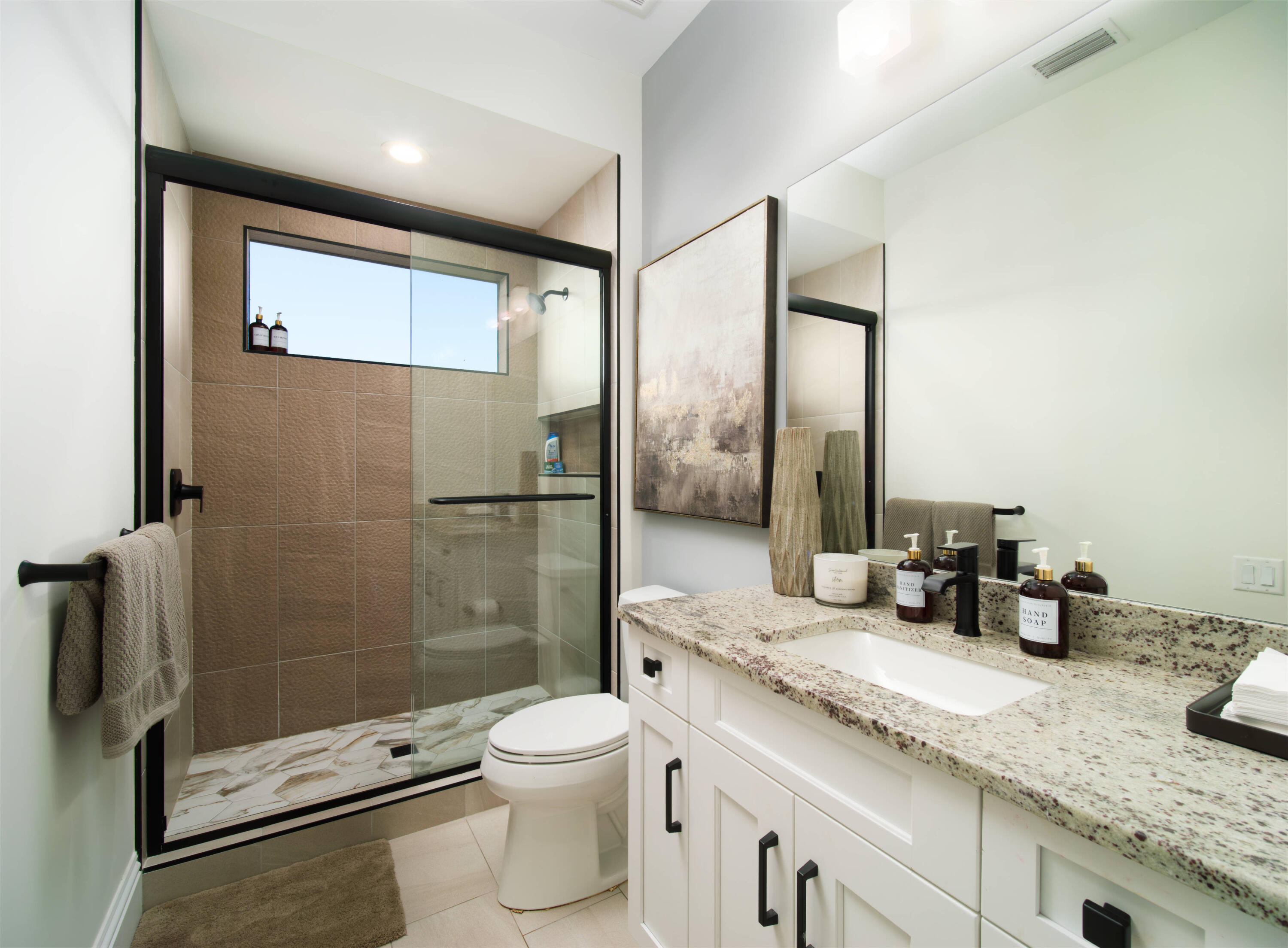 7683 Pelican Pointe Drive Jensen Beach, FL 34957 - Photo 23 of 40 a bathroom with a granite countertop sink a toilet a mirror and shower
