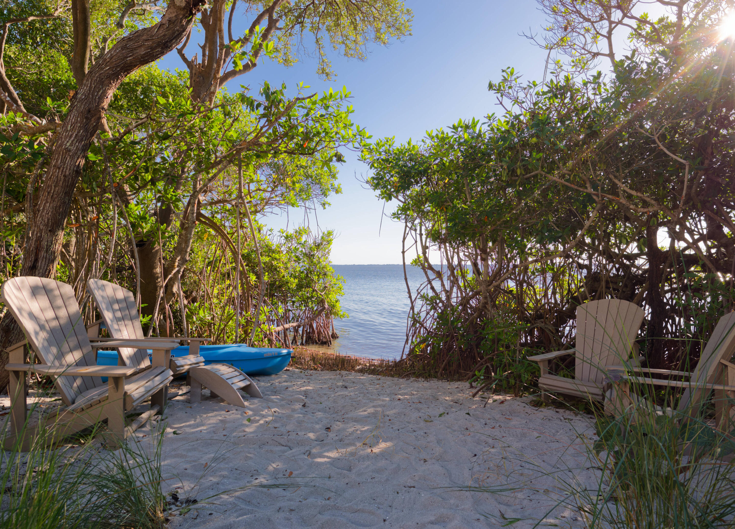 7683 Pelican Pointe Drive Jensen Beach, FL 34957 - Photo 33 of 40 a backyard of a house with table and chairs under an umbrella