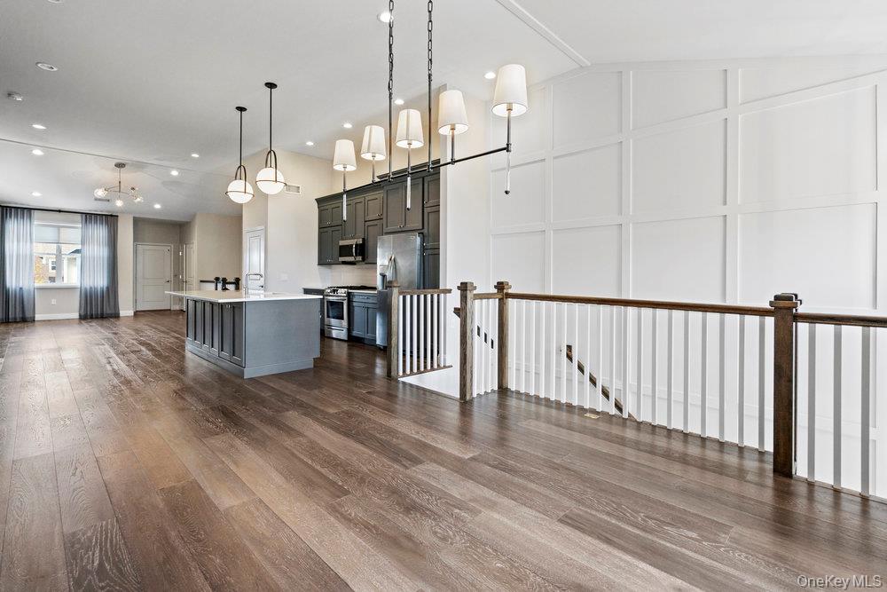 295 Silver Timber Drive Yaphank, NY 11980 - Photo 50 of 50 a open kitchen view with stainless steel appliances granite countertop a stove top oven a refrigerator and a dining table with wooden floor