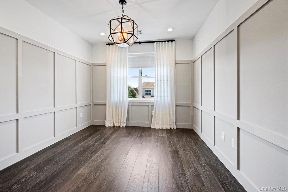 295 Silver Timber Drive Yaphank, NY 11980 - Photo 16 of 50 a view of a kitchen from the hallway with wooden floor and staircase