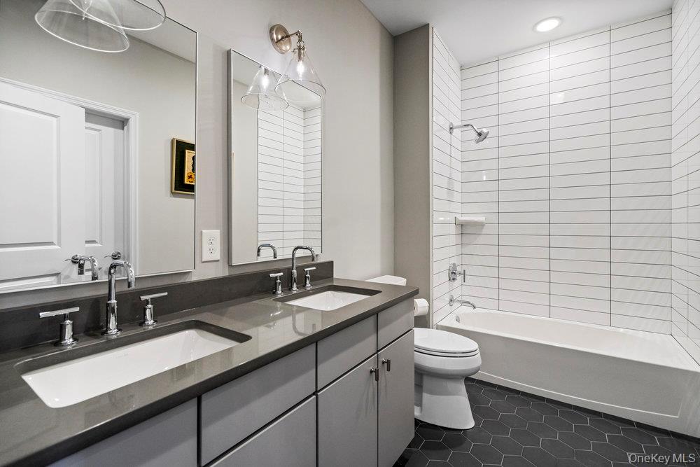 295 Silver Timber Drive Yaphank, NY 11980 - Photo 17 of 50 a bathroom with a double vanity sink toilet and shower
